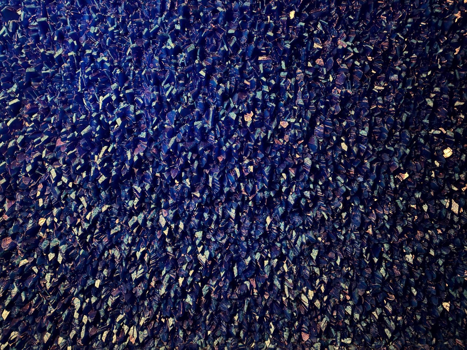 A close view of a wall covered in deep blue copper sulphate crystals