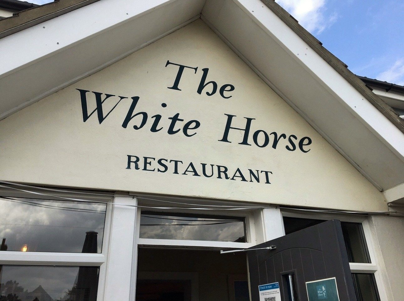 The painted sign above the entrance to the White Horse restaurant at Brancaster Staithe